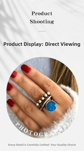 Macro shot of silver ring with large blue gem and five white pearls on model finger