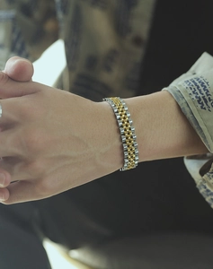 Close-up of a two-tone gold and silver steel jubilee bracelet worn on a male wrist