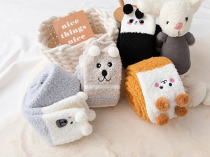 Close-up of fluffy coral fleece over-knee socks featuring cute animal face designs