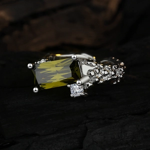 Silver ring with green rectangular gemstone and white stones on bubble texture band
