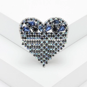 Dettaglio della spilla a cuore con cristalli blu ed eleganti nappe scintillanti
