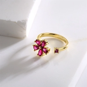 Vista dettagliata di un anello d'oro regolabile con un fiore di zircone rosso brillante