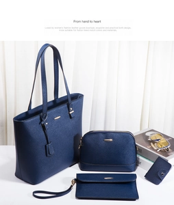 Detail of four-piece navy blue leather bag set with tote, pouch and gold hardware