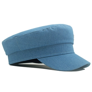 Détail d'une casquette de marin en jean bleu avec texture sergé et bouton métallique
