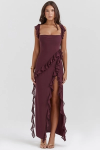 Dettaglio dell'abito lungo bordeaux con bordo a balze e spacco alto per occasioni eleganti