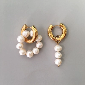 Detail of asymmetrical baroque freshwater pearl earrings with golden huggie hoop charms
