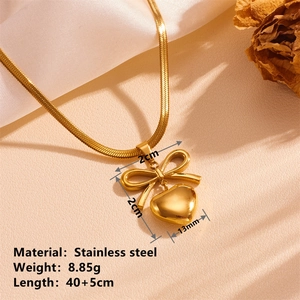 Detail of gold stainless steel bow and heart necklace with precise dimension specifications