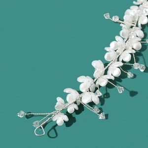 Handmade clover floral hair clip set with white petals and beads on green background