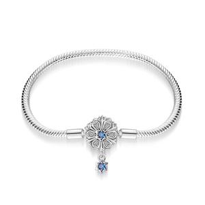 Detailed close-up of flower charm with blue stones and star pendant on silver snake chain