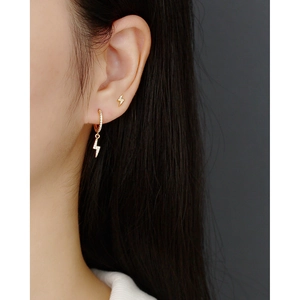 Close-up of gold S925 sterling silver hoop earrings with lightning bolt charms and cubic zirconia