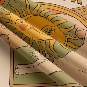 Close-up of vintage tarot style sun and cat paw print on textured twill tapestry fabric