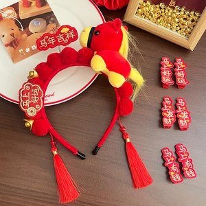 Detail of red Year of the Horse headband with tassels and festive gold plush charms
