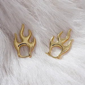 Punk style gold flame huggie earrings with lava irregular metal curves on white fur