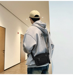 Rear view of a model wearing the black washed denim mini crossbody bag in a hallway