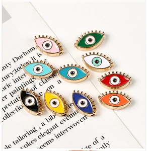 Macro view of ten colorful alloy evil eye charms with enamel finish and dual side holes