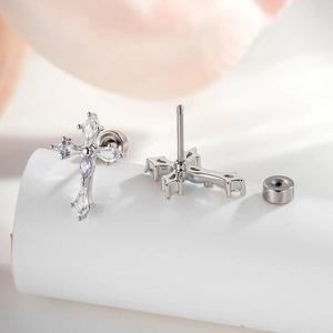 Silver cross stud earrings featuring clear and lavender rhombus zircons in a macro shot