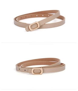 Detail view of a slim beige leather belt for women featuring a gold rectangular metal buckle