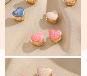 Detail of marble pattern resin heart earrings with gold-plated metal base and enamel finish