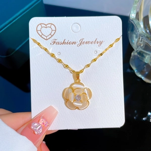 Luxurious gold titanium necklace with cat-eye flower pendant on a jewelry card