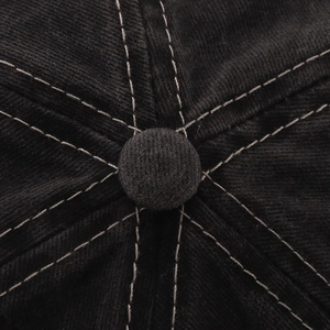 Detailaufnahme des oberen Knopfes einer Vintage-Baseballkappe mit weißen Kontrastnähten