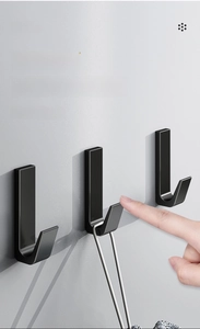 Close-up of matte black adhesive wall hooks with rounded corners and L-shaped design