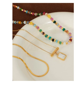 Close-up of 18K gold-plated necklaces with sugar cube shell pendant and colorful beads