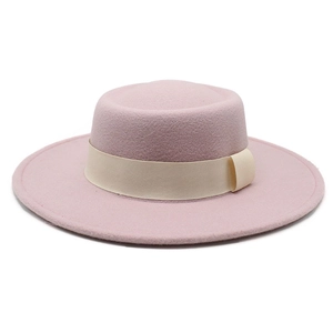 Detail of pink wool boater hat featuring a cream wide ribbon and elegant felt texture