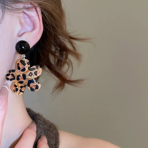 Seitenansicht eines Models mit Acryl-Ohrringen mit Leopardenmuster in Blumenform