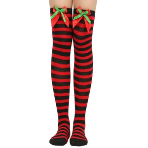 Close-up of red and black striped over-knee socks with green ribbon bow detail