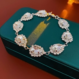 Gros plan d'un bracelet argenté avec pendentif goutte d'eau sur une boîte à bijoux