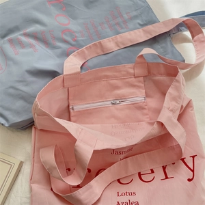 Détail de la poche intérieure zippée et de l'imprimé floral sur les sacs cabas