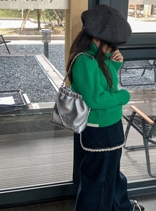 Silberne Metallic-Kettentasche für Kinder, getragen von einem Mädchen im grünen Pullover
