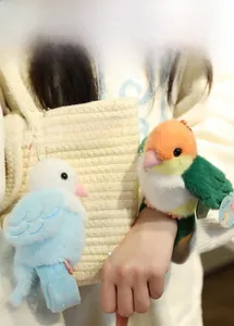 Plush bird snap bracelets in blue and green shown on a wrist and a fabric bag