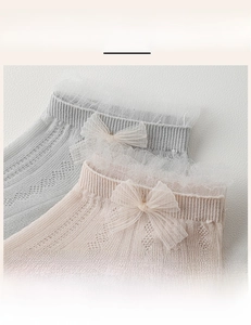 Close-up of elastic ribbed cuffs with lace trim and bows on mesh summer socks