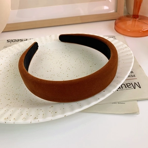 Detailed texture of a wide vintage dark brown velvet headband on a decorative plate