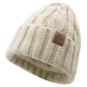 Detailed view of beige cable knit beanie with thick fleece lining and brown leather tag