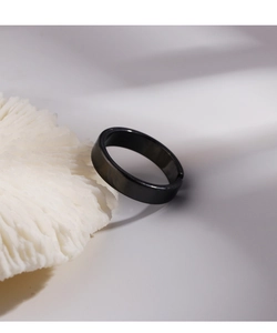 Minimalist black open ring with a polished glossy finish on a decorative display