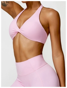 Détail de la brassière de yoga licou rose clair avec nœud et tissu de sport élastique