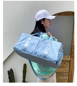 Light blue large sports gym bag shown on shoulder of model for travel or fitness use