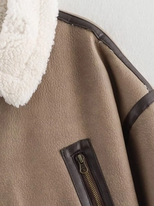 Close-up of tan faux leather jacket featuring white shearling collar and metal zipper