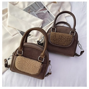 Detail of plush faux suede brown handbag with round handles and fuzzy patchwork texture