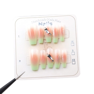 Pink and green gradient press-on nails with rhinestones on a white display card