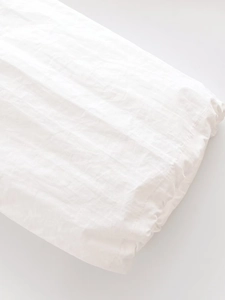 Gros plan détaillé des coutures et de la texture du tissu blanc coupe-vent du pantalon