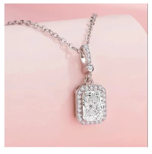 Macro shot of s925 silver necklace with square cut crystal pendant on pink background