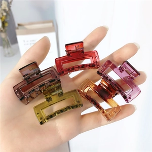 Set of five colorful square hair claws held in hand to show size and translucent finish