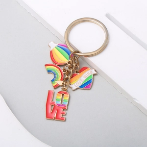 Détail du porte-clés doré avec charms de montgolfière arc-en-ciel et cœurs