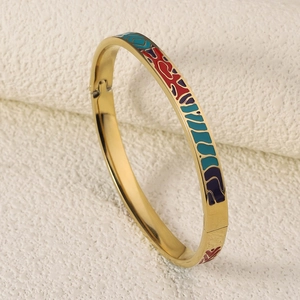 Detailed macro view of gold-plated bangle featuring colorful enamel geometric patterns