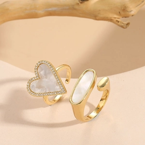 Detail of gold heart and oval rings with mother-of-pearl inlay and sparkling zircon crystals