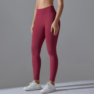 Detail of high-waist seamless compression yoga leggings with ribbed waistband and dark red finish