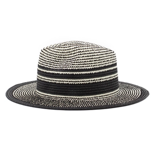 Close-up of the fine woven texture on a black and beige striped boater straw hat